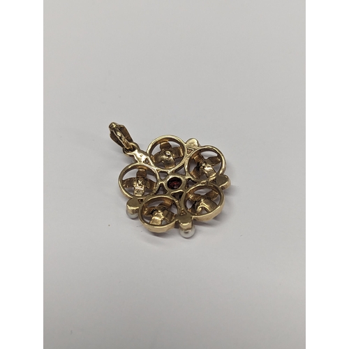 174 - A 9ct gold pendant A/F inset with central garnet and nine pearls in a floral design 4.5g
Location: C... 