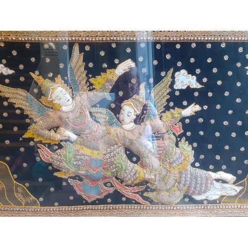 141 - A mid to late 20th Century large Thai embroidered picture depicting 2 goddesses flying with wings ag... 