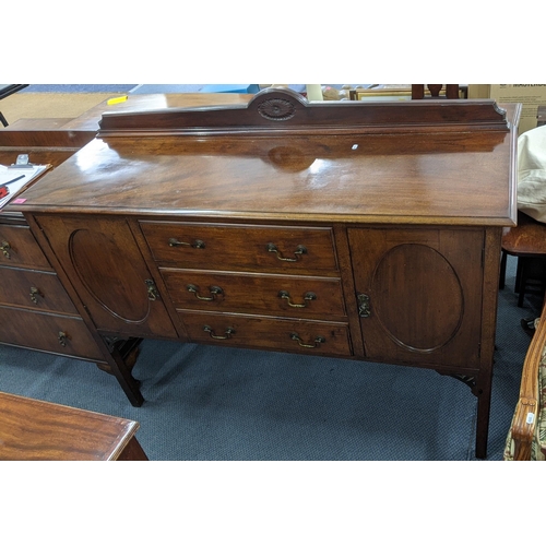 160 - An early 20th century mahogany sideboard having a raised back, three drawers and two cupboard doors ... 