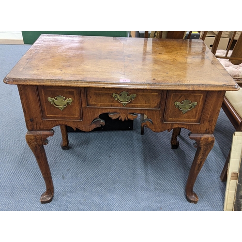 17 - An early  18th century quarter cut veneered walnut lowboy having three drawers and a carved apron 70... 