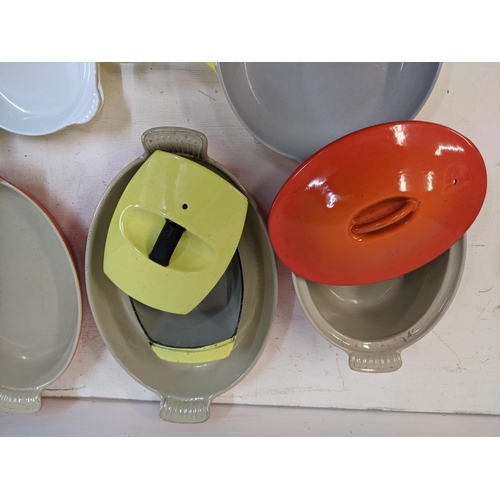 26 - A collection of enamel kitchenware to include some Le Creuset enamel severing and casserole dishes a... 