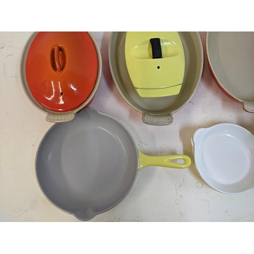 26 - A collection of enamel kitchenware to include some Le Creuset enamel severing and casserole dishes a... 