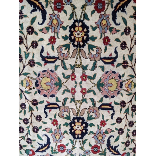 35 - A Persian Tabriz rug with a red floral border, and a symmetrical design with plants and flowers in b... 