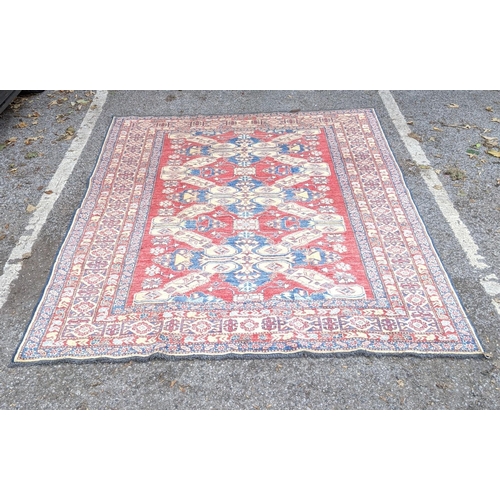 36 - A Caucasian Kazak rug decorated with three central motifs and a repeating abstract blue and cream bo... 