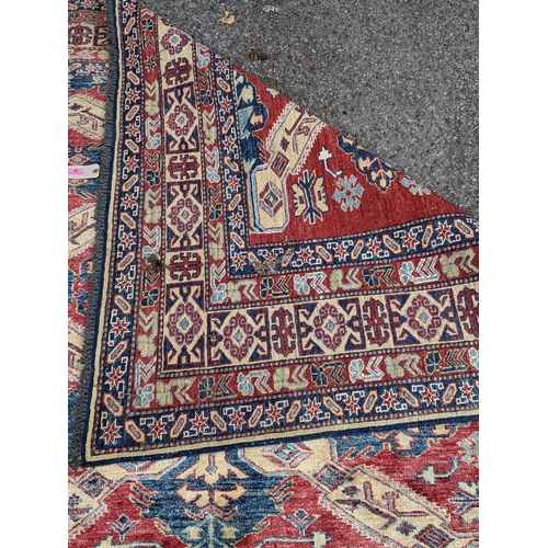 36 - A Caucasian Kazak rug decorated with three central motifs and a repeating abstract blue and cream bo... 