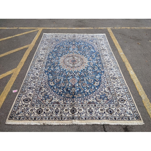 37 - An Isfahan port silk rug with a floral cream border decorated with simplistic flowers and a large ce... 