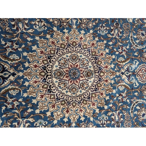 37 - An Isfahan port silk rug with a floral cream border decorated with simplistic flowers and a large ce... 