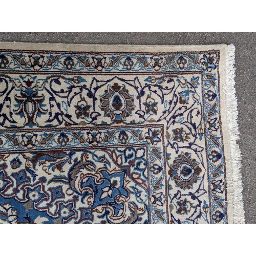 37 - An Isfahan port silk rug with a floral cream border decorated with simplistic flowers and a large ce... 