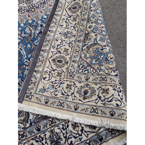 37 - An Isfahan port silk rug with a floral cream border decorated with simplistic flowers and a large ce... 