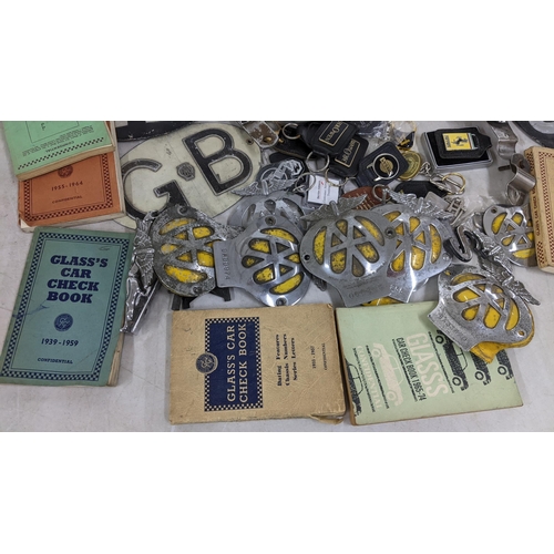 402 - A selection of car related items to include AA badges, Jaguar mascot, glass's car check book and oth... 