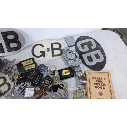 402 - A selection of car related items to include AA badges, Jaguar mascot, glass's car check book and oth... 