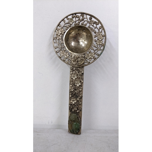 404 - A Chinese white metal tea strainer with pierced floral decoration and inset with jade to the handle
... 