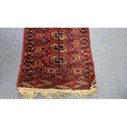 82 - A hand woven Persian design red ground small rug having elephant foot motifs and multiguard borders,... 