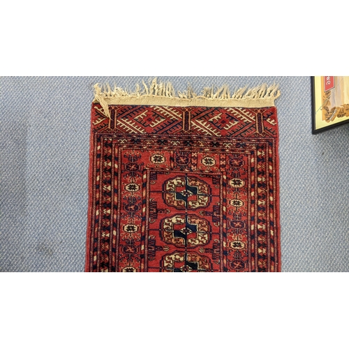 82 - A hand woven Persian design red ground small rug having elephant foot motifs and multiguard borders,... 