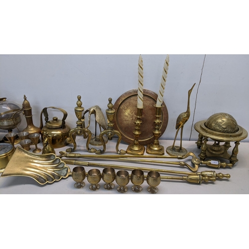 86 - A mixed lot of brassware to include fireside irons, barometer, fire dogs, trench art and other items... 