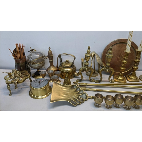 86 - A mixed lot of brassware to include fireside irons, barometer, fire dogs, trench art and other items... 