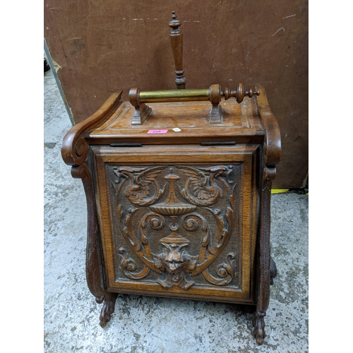 228 - A late 19th century carved oak coal scuttle with carved ornament to the front, metal liner and woode... 