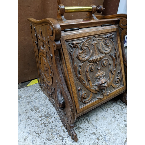 228 - A late 19th century carved oak coal scuttle with carved ornament to the front, metal liner and woode... 