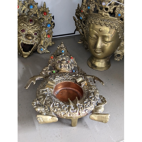 140 - An Oriental gilt metal incense burner cast as the head of Mahakala, together with a Buddha head and ... 