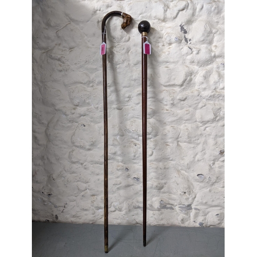 282 - Two walking sticks one with an added carved wooden dog head handle and the others, a bowling ball
Lo... 