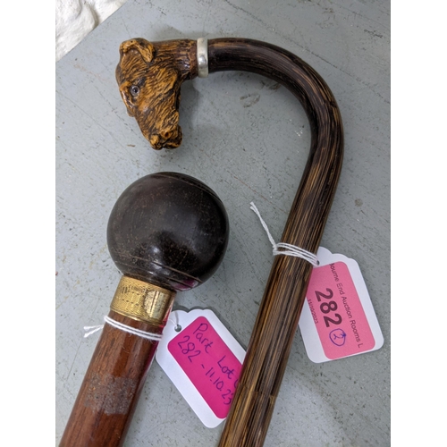 282 - Two walking sticks one with an added carved wooden dog head handle and the others, a bowling ball
Lo... 