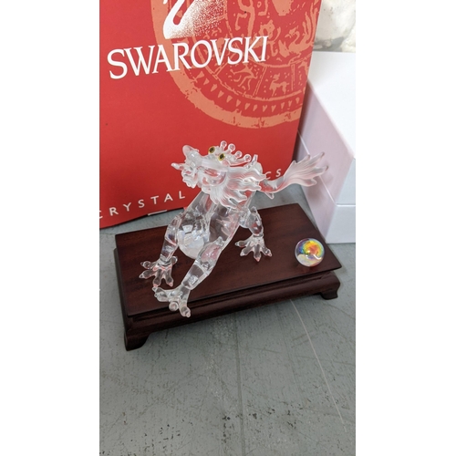 446 - A Swarovski crystal model of a dragon having yellow eyes on a plinth in its box
Location: R2.4