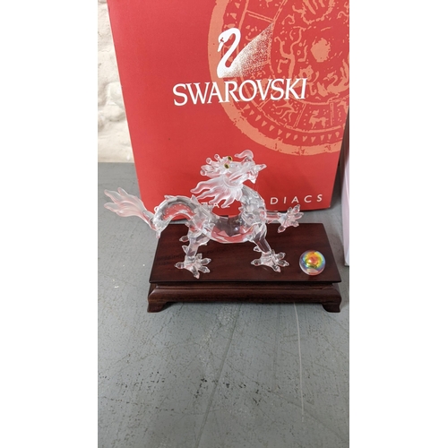 446 - A Swarovski crystal model of a dragon having yellow eyes on a plinth in its box
Location: R2.4