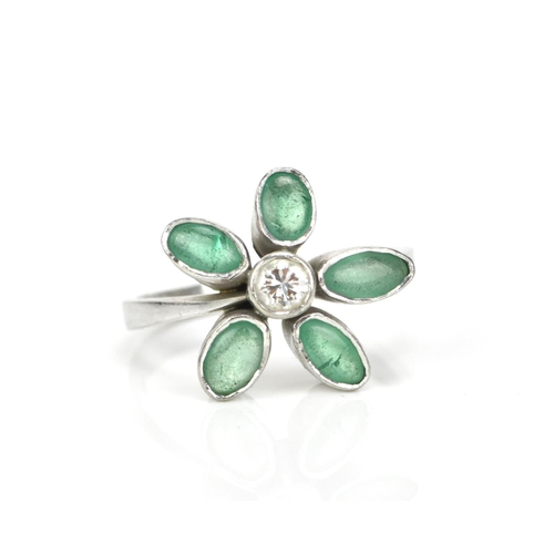 375 - A white metal, emeralds and diamond floral ring, with central bezel set brilliant cut diamond in a s... 