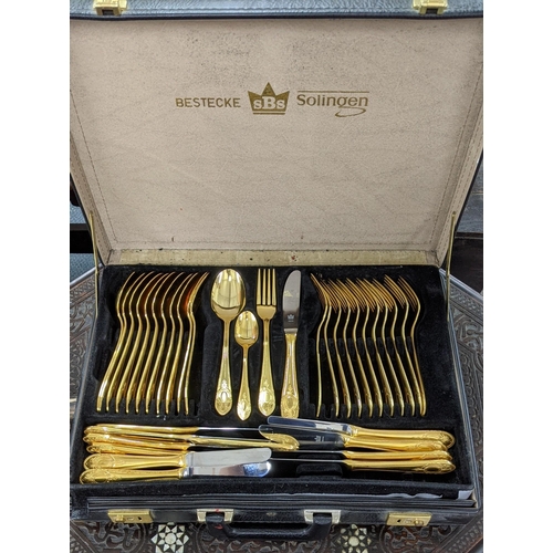 473 - A German Solingen Bestecke gold plated canteen of cutlery and flatware contained in a attaché style ... 