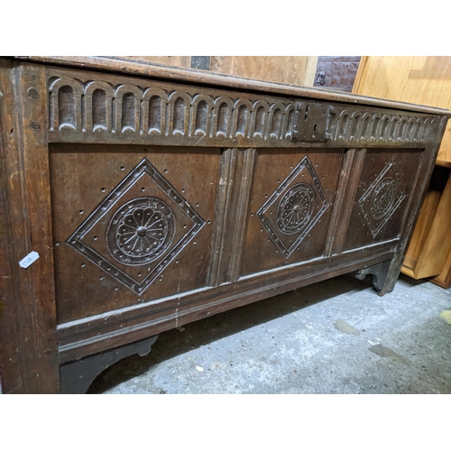 359 - An 18th century oak carved coffer, three panel front, hinged top with moulded edge, on stile feet 60... 