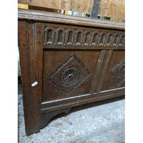 359 - An 18th century oak carved coffer, three panel front, hinged top with moulded edge, on stile feet 60... 