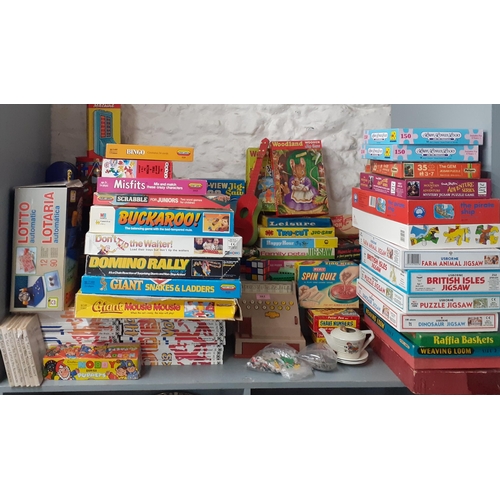 383 - A quantity of vintage puzzles, games and toys to include Waddingtons jigsaw puzzles, a child's cash ... 