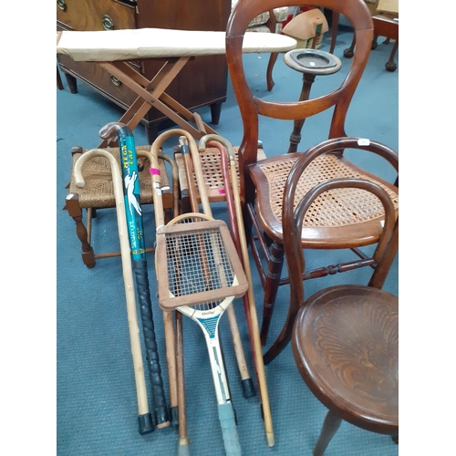 388 - A vintage child's ironing board, 2 cane topped stools, walking canes, a Dunlop tennis racket and hoc... 