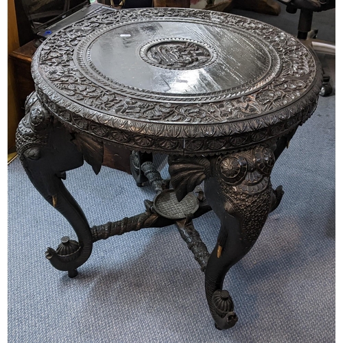 390 - A late 19th/early 20th century Indian heavily carved circular topped occasional table, the four legs... 