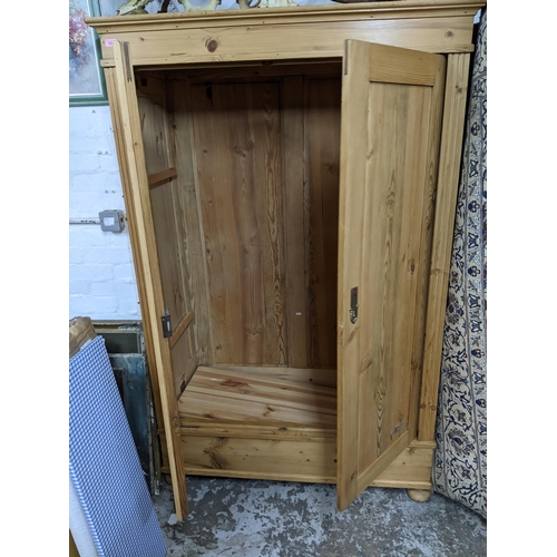 522 - An early 20th century pine wardrobe with twin doors on bun shaped feet 186cm x 121cm x 60cm Location... 