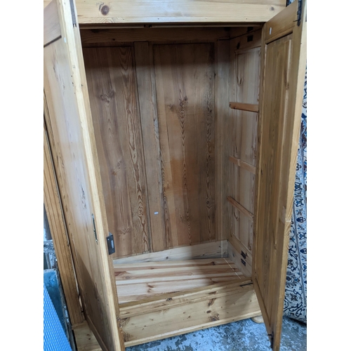 522 - An early 20th century pine wardrobe with twin doors on bun shaped feet 186cm x 121cm x 60cm Location... 