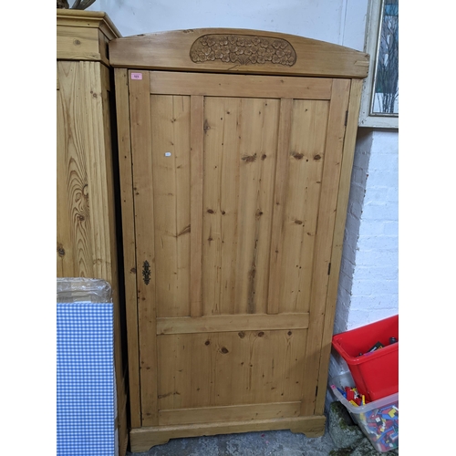 523 - An Edwardian pine single door wardrobe with carved floral motif to pediment, standing on bracket fee... 