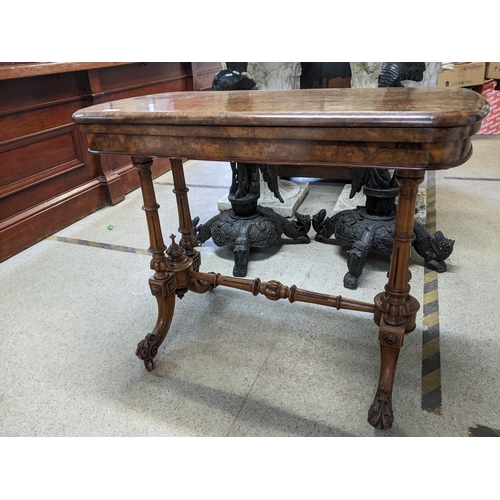 533 - A Victorian fold over swivel top walnut card table on turned columns and splayed legs 74cm x 92cm x ... 