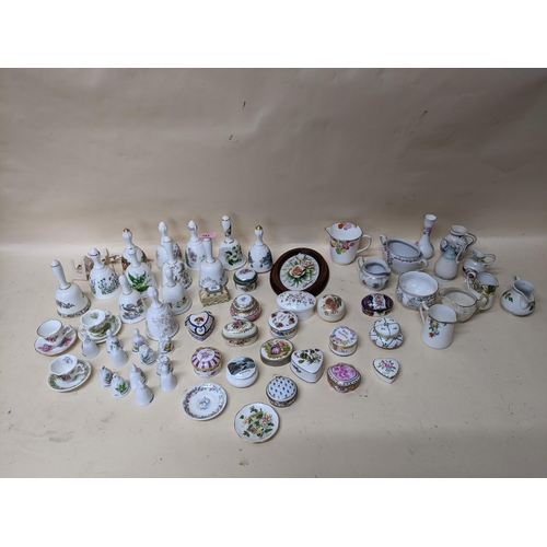 343 - A group of porcelain collectables to include various pill boxes, porcelain bells, mini cups and sauc... 