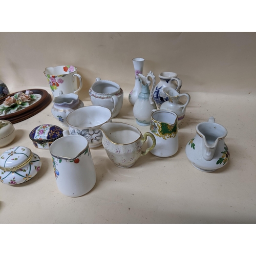 343 - A group of porcelain collectables to include various pill boxes, porcelain bells, mini cups and sauc... 