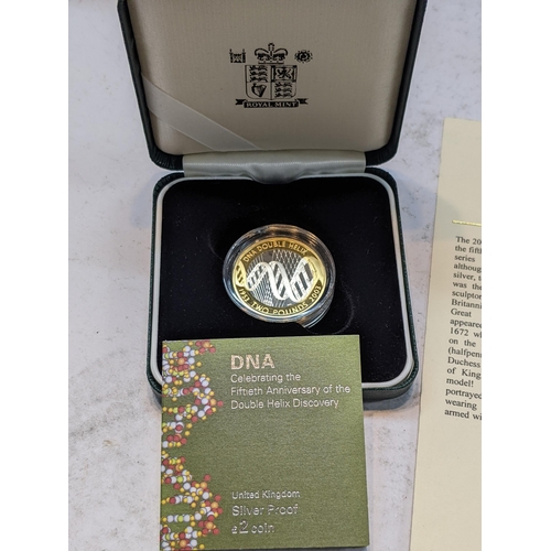 508 - A group of three UK silver proof coins to include the 2003 DNA £2 cased, 1992 10-pence coin, and a 2... 