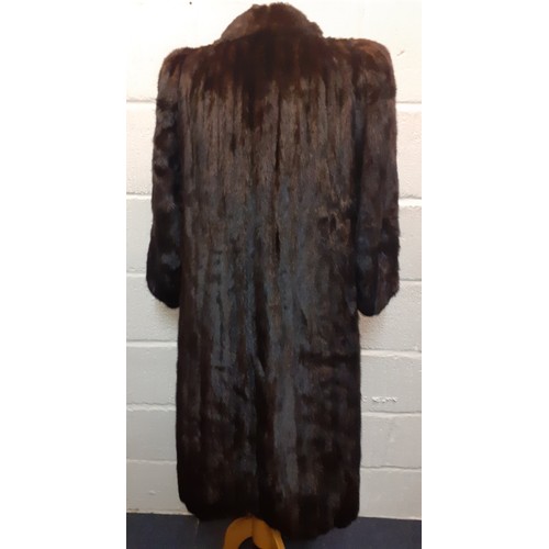23 - A 1980's dark brown mink coat (almost black to the eye) having a shawl collar, raised and padded sho... 