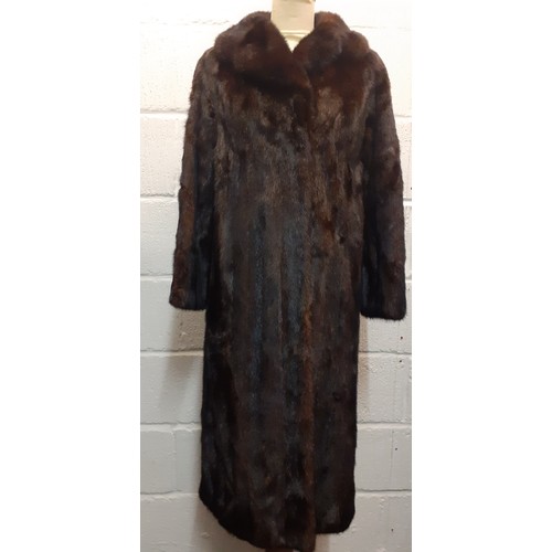 24 - A late 20th Century dark brown (almost black to the eye) mink coat having a shawl collar and a brown... 