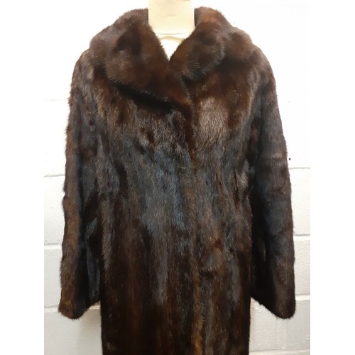 24 - A late 20th Century dark brown (almost black to the eye) mink coat having a shawl collar and a brown... 