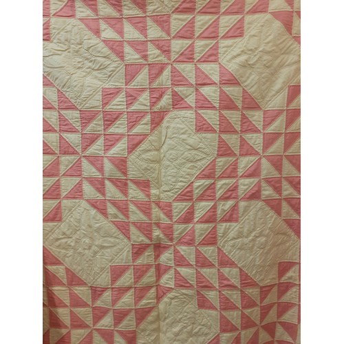36 - A 1970's American Mid West handmade double layer patchwork quilt in pink, white and cream having a m... 