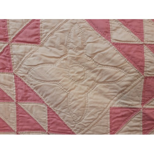 36 - A 1970's American Mid West handmade double layer patchwork quilt in pink, white and cream having a m... 