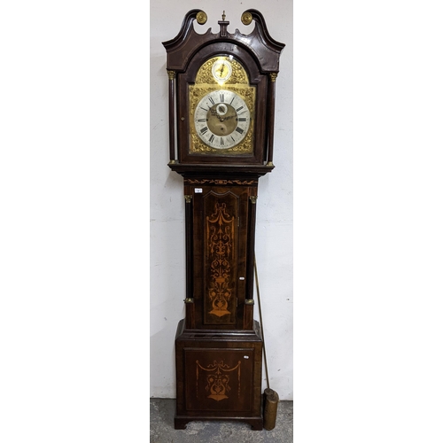 A George III mahogany musical longcase clock, the case having a broken swan neck pediment, marquetry inlaid and Corinthian columns flanking the arched top dial having a matted brass centre, silvered chapter ring, subsidiary seconds dial, chime/silent dial, pierced gilt metal spandrels and eight bells/Westminster selection lever, the 8 day movement striking on a nest of eight graduating bells and one large bell, 226cm high x 50.5cm wide