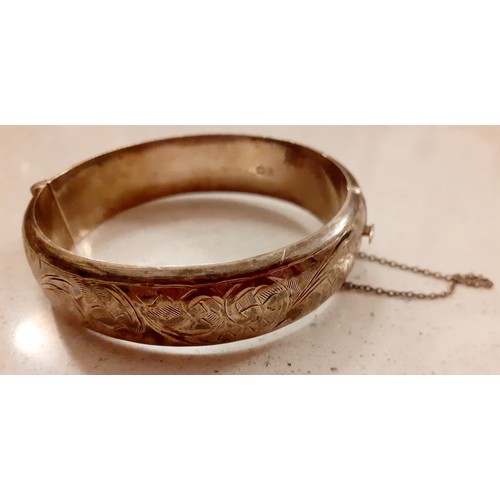 82 - A quantity of costume jewellery to include an engraved silver bangle stamped with the makers mark JS... 