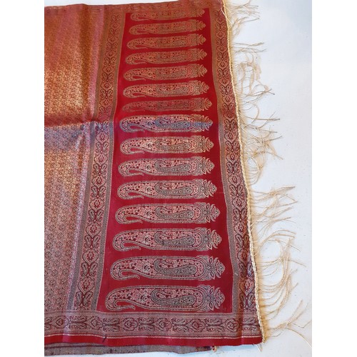 91 - An Indian machine made metallic thread shawl having a red ground with a boteh border and gold metall... 