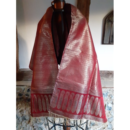 91 - An Indian machine made metallic thread shawl having a red ground with a boteh border and gold metall... 